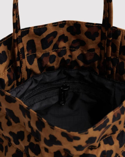 Leopard print nylon drawstring bag with black interior and front zip pocket