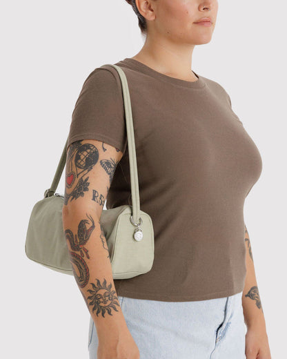 Celadon nylon loaf bag worn over shoulder; curved handle and top zipper.
