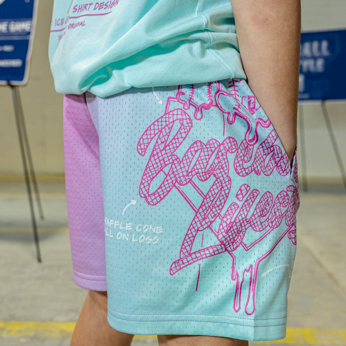 Pink-blue shorts with a BL101 logo and text on a person wearing a light green shirt.