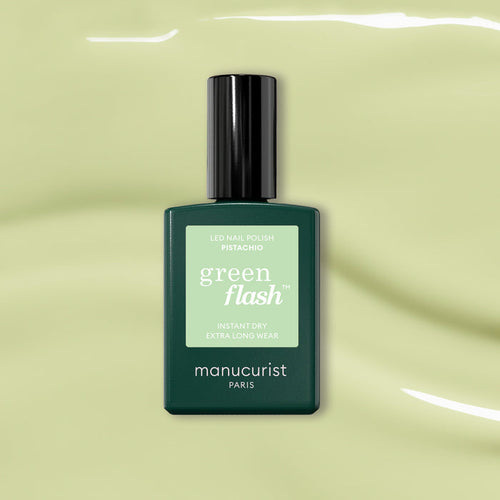 A bottle of Manucurist Pistachio, a pale green LED gel polish with yellow undertones, is shown on a glossy light green background.
