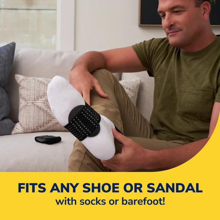 Black arch support sleeve on a foot with textured non-slip base and secure strap