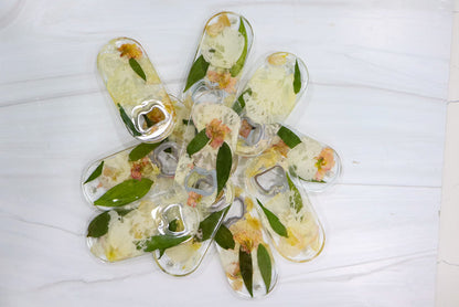 Landscape photo of a pressed flower bottle opener with dried flowers in a resin handle
