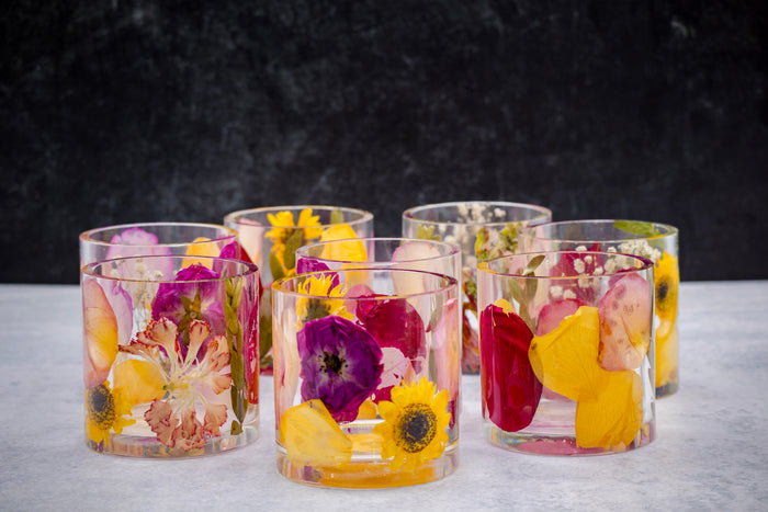 Landscape photo of a pressed flower round resin ring holder with mixed dried botanical layers
