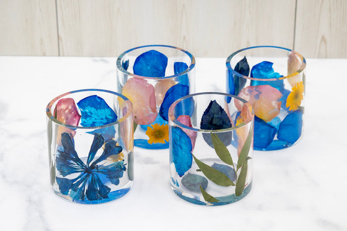 Landscape photo of a pressed flower round resin ring holder with colourful mixed dried blooms