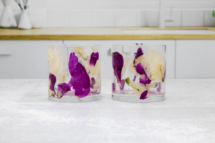 Landscape photo of a pressed flower whiskey cup with soft dried roses on a styled surface