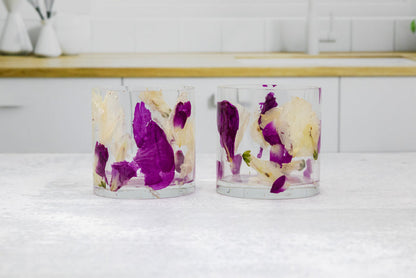 Landscape photo of a pressed flower whiskey cup with soft dried roses on a styled surface
