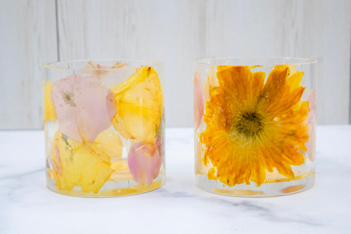 Landscape photo of a pressed flower round resin ring holder with vibrant tropical dried flowers