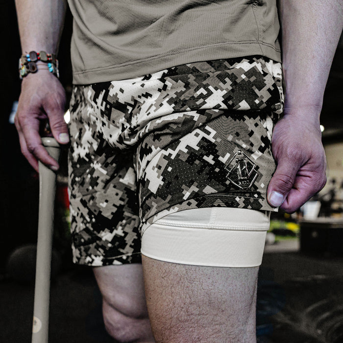 Person wearing camouflage shorts with a visible brand logo.