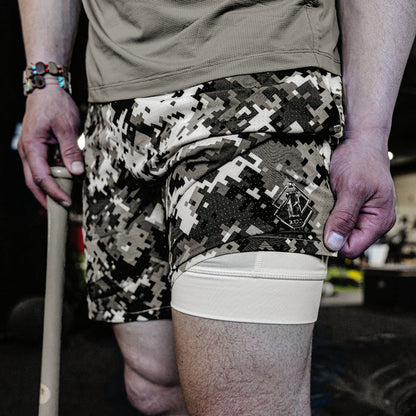 Person wearing camouflage shorts with a visible brand logo.