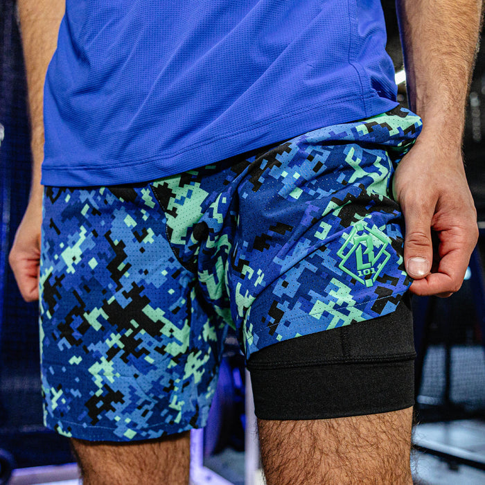 Person wearing blue athletic shorts with a digital camouflage pattern.