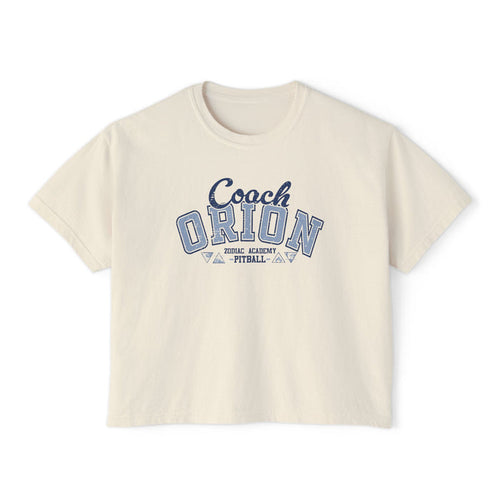 A vintage wash cream comfort colors cropped t-shirt from thtgrlreads featuring a blue collegiate-style "Coach Orion" graphic, part of the Zodiac Academy collection.