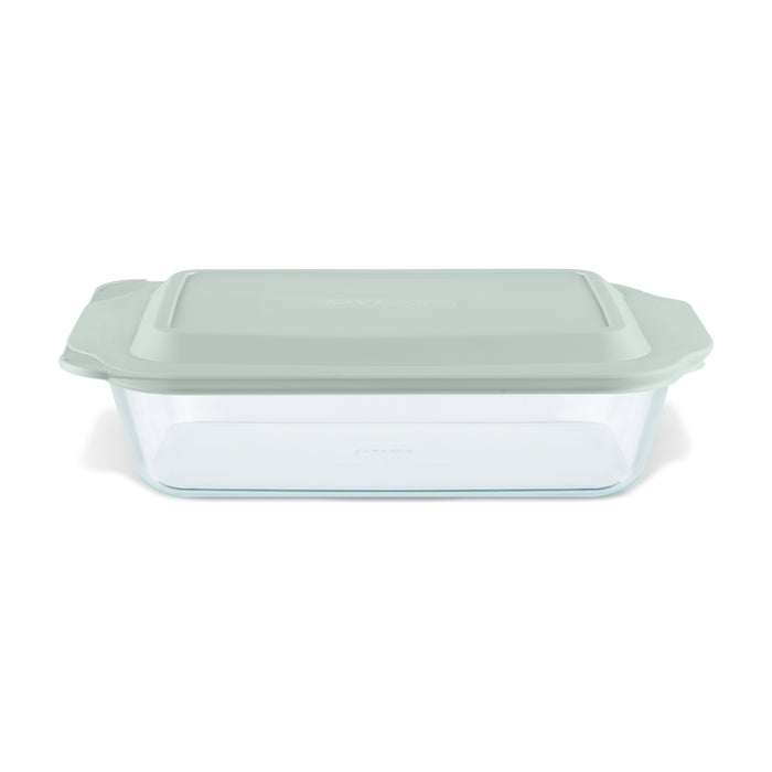 Glass baking dish with a green lid on a white background