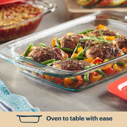 Glass baking dish with meat and vegetables on a countertop, with text 'Oven to table with ease'.