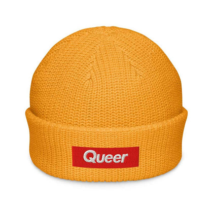 Gold beanie with a red 'Queer' patch on a white background