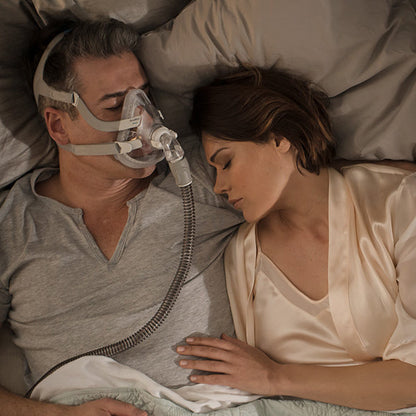 Man in bed wearing a Full Face CPAP Mask with a Resmed Quietair Elbow