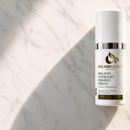 Reiland Beauty Products HydraLift Firming Serum standing on a sunlit marble surface, featuring hyaluronic acid, ginseng, and fruit extracts.