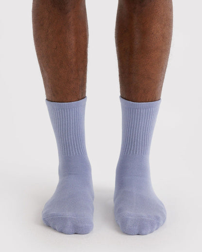 Ribbed mist blue socks on feet with ribbed cuff and rounded toe.
