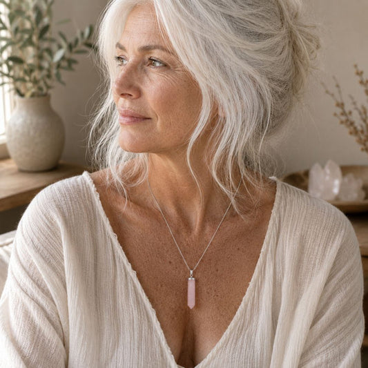 Woman wearing a Rose Quartz crystal point pendant on a simple silver chain.