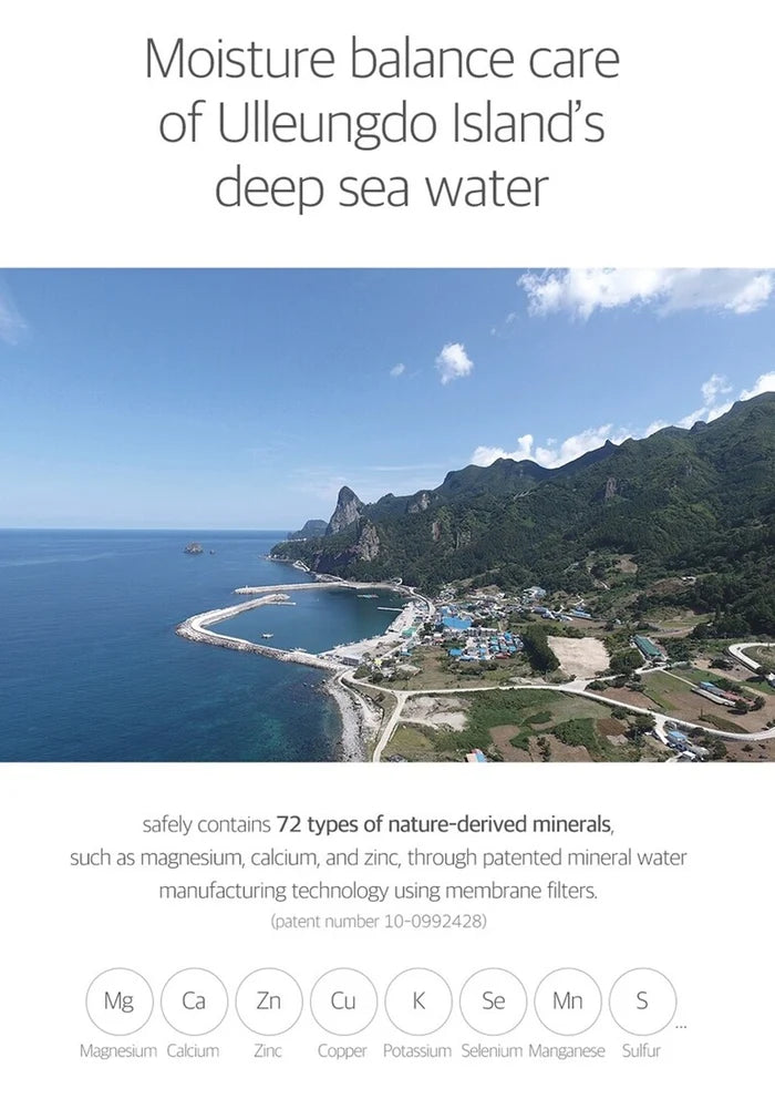 Scenic view of a coastal area with mountains and clear blue sky, promoting moisture balance care from Ulleungdo Island's deep sea water.