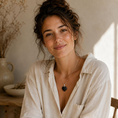 Woman wearing a polished Shungite heart pendant on a delicate silver chain.