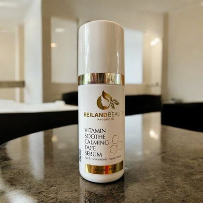 Reiland Beauty Products Vitamin Soothe Calming Face Serum bottle placed on a polished counter in a modern, well-lit room. Features a calming formula with lipids, antioxidants, and amino acids to nourish and soothe sensitive skin.