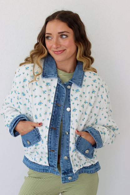 Woman wearing a floral denim jacket with a white background