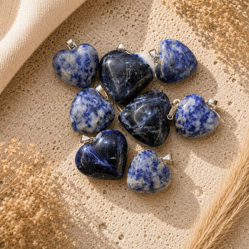 Sodalite heart crystal pendants with silver bails on a neutral textured background.