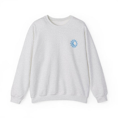 A cozy vintage-washed Comfort Colors crewneck sweatshirt from thtgrlreads featuring a small blue sun and crescent moon graphic, part of the Kindred's Curse Saga collection by Printify.
