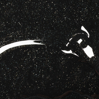 A lightbulb rests on Manucurist's Sparks, a shiny black glitter gel polish surface resembling a starry night sky, with reflections highlighting the bulb and sparkling particles scattered throughout.