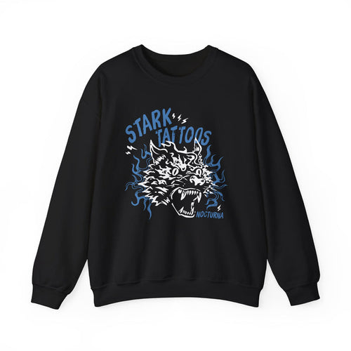 Wolves of Ruin collection by thtgrlreads features a black oversized crewneck sweatshirt from Printify with a vintage wash, showcasing a bold blue and white graphic of a snarling wolf surrounded by stylized flames and the words "Stark Tattoos.
