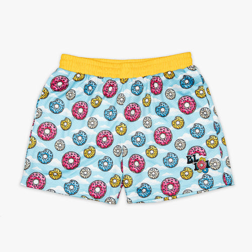 Youth model wearing multi-color youth shorts with “Sugar Rush Donut” design