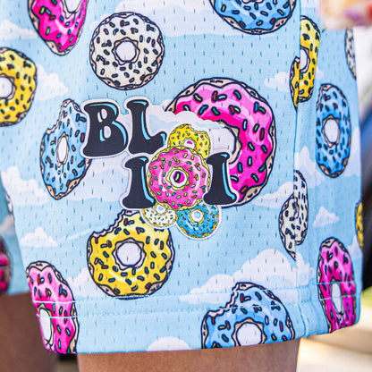 Youth model wearing multi-color youth shorts with “Sugar Rush Donut” design