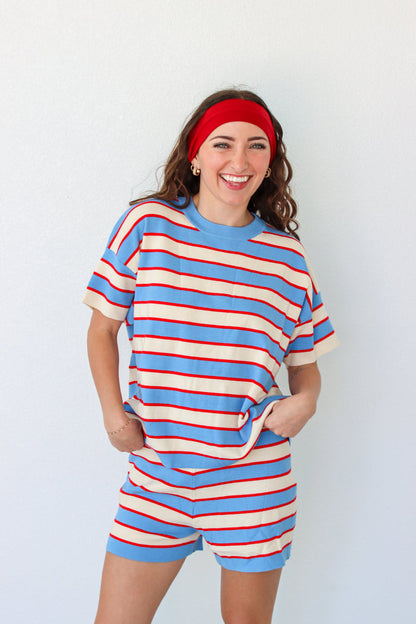 Woman wearing a blue and red striped outfit with a headband against a white background