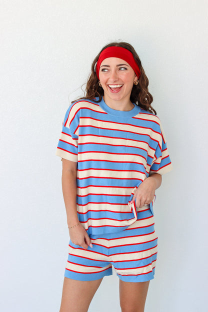 Woman wearing a blue and red striped outfit with a headband against a white background