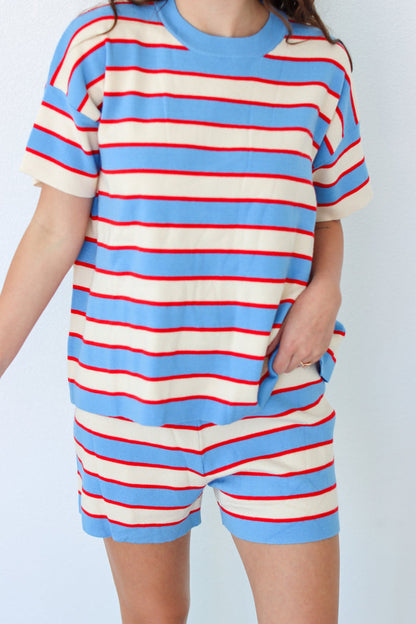 Woman wearing a blue and red striped outfit with a headband against a white background