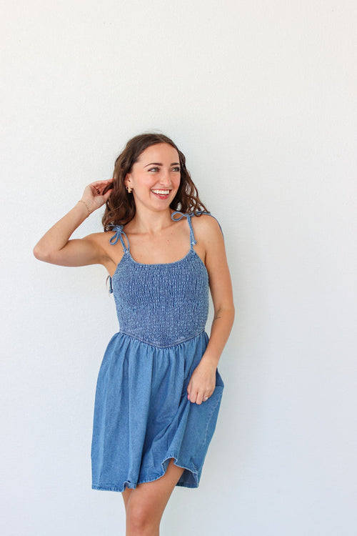 Woman wearing a blue denim dress against a white background