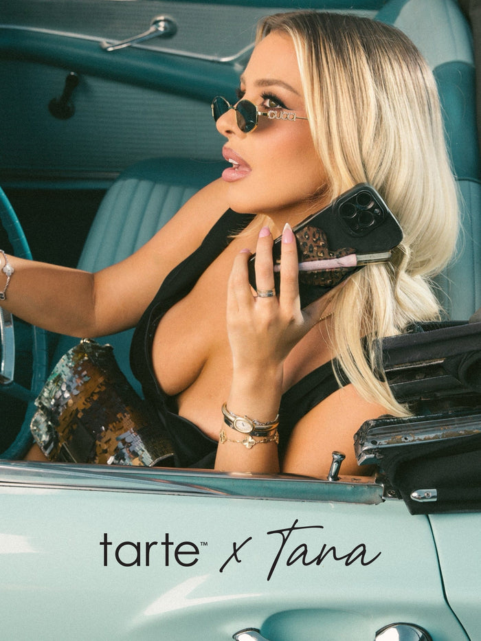 Woman in a vintage car with 'tarte x Tana' branding