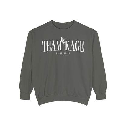 Bloodwing Academy crewneck sweatshirt from thtgrlreads featuring a vintage-wash, soft gray Comfort Colors fabric with bold white "TEAM KAGE" text and a small graphic print.