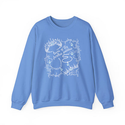 A cozy blue oversized crewneck sweatshirt from thtgrlreads featuring a vintage white intricate line art design with text "tears of the faceless goddess," part of the Wolves of Ruin collection, printed on a premium Comfort Colors base by Printify.
