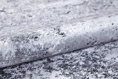 A close-up of textured wallpaper with a metallic silver-gray marbled design and black speckles, a reflective finish, and ideal for pairing with the Techno Flux - Washable Rug - JR1814 to enhance any modern space.