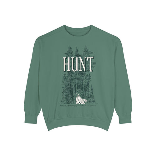 Thtgrlreads oversized crewneck from The Poison Daughter collection featuring vintage-wash green Comfort Colors fabric with a detailed graphic of a forest and a flowing-dress figure beneath "The Hunt" text in serif font.