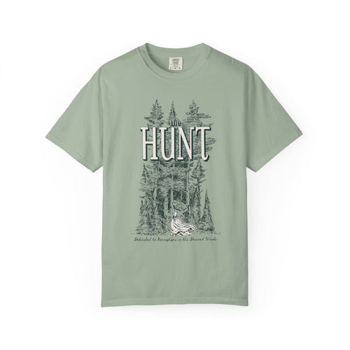Thtgrlreads The Poison Daughter collection features a sage green Comfort Colors graphic tee with vintage wash and a detailed forest scene surrounding the large "HUNT" text in a classic font.
