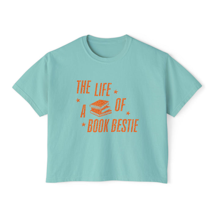 Thtgrlreads women's cropped Comfort Colors tee from The Life of a Book Bestie collection featuring vintage orange text and stacked books graphic on a soft light blue fabric.