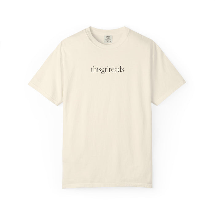 Thtgrlreads bookish apparel featuring a vintage wash Comfort Colors cream graphic tee with minimalist black serif text "thisgrlreads," part of the Tees and Book Bestie collections.