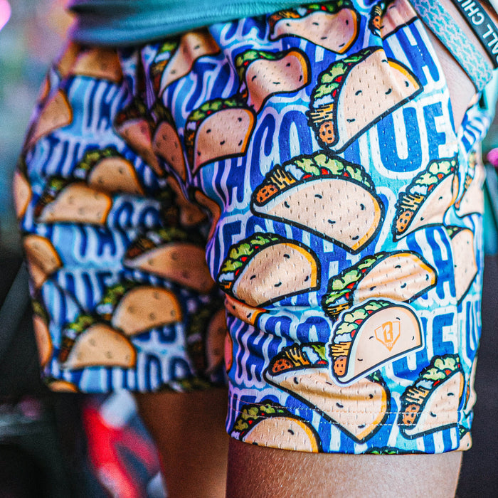 Shorts with a colorful pattern of tacos on a blue background.
