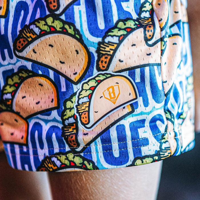 Colorful shorts with taco design and text on a blue background