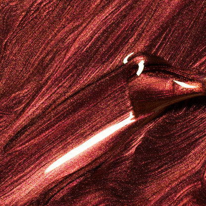 Close-up of Manucurist's Utopia, a shimmering metallic burgundy gel polish, being brushed on for smooth, reflective waves—perfect for fans of glossy, metallic finishes.